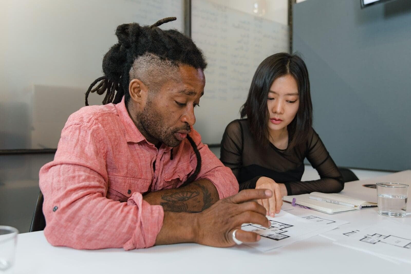 Two colleagues reviewing plans together at a table